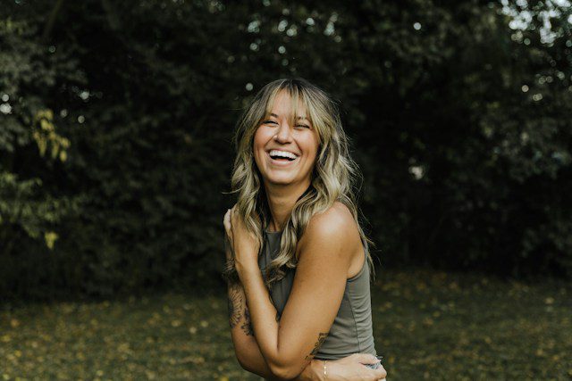 empowered woman laughing in forest after healing from limerence